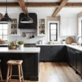 Photorealistic interior of a sunlit farmhouse kitchen featuring black lower cabinets, white Shaker-style upper cabinets, a Carrara marble waterfall island, industrial pendant lights, and a white subway tile backsplash, all accented by natural light and wide-plank oak flooring.