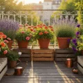 Cinematic overhead view of a sunlit urban balcony garden during golden hour, showcasing vibrant zinnias, lavender, and petunias in weathered pots, with warm light casting shadows on rustic floorboards and a blurred cityscape in the background.