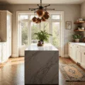 Photorealistic interior of a sunlit luxury kitchen with cream shaker cabinets, Calacatta marble waterfall island, and white oak herringbone floors, featuring natural light, hanging copper pots, and potted herbs, captured in 8K resolution with dramatic depth of field and warm golden hour tones.
