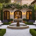 Photorealistic image of a Mediterranean courtyard garden at sunset, featuring a central travertine fountain, symmetrical boxwood parterres, climbing roses, and aged limestone walls, with warm evening light casting shadows across cobblestone paths and illuminated by string lights and copper lanterns.