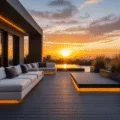 A cinematic ultra-wide shot of a luxurious L-shaped black composite deck at sunset, featuring dramatic shadows, modern seating, LED lighting, and ornamental grasses, captured in hyper-realistic detail with teal and orange color grading.