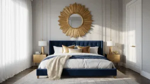 10 Stunning Bedroom Mirror Ideas to Transform Your Space A luxurious master bedroom with a dramatic oversized antiqued gold sunburst mirror above a navy blue velvet platform bed, bathed in golden hour sunlight filtering through sheer white curtains. The room features pale grey walls, layered white linens, chunky ivory throws, and metallic pillows, with dark hardwood floors reflecting subtle glints.