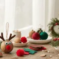 Cozy crafting corner with DIY Christmas ornament materials, featuring a completed Rudolph walnut ornament, elegant velvet-wrapped ornaments, mason jar lid wreaths, dried orange slices, and miniature ornaments, all bathed in warm, soft natural light.