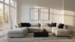 Cinematic wide-angle shot of a modern living room featuring a warm white wall, soft gray sectional, and black accents, illuminated by golden hour light.